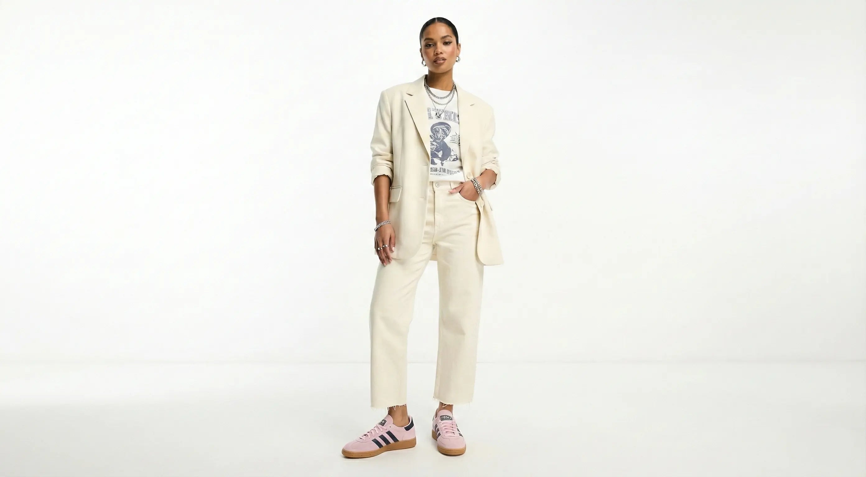 Person wearing a beige suit with a graphic t-shirt on a white background