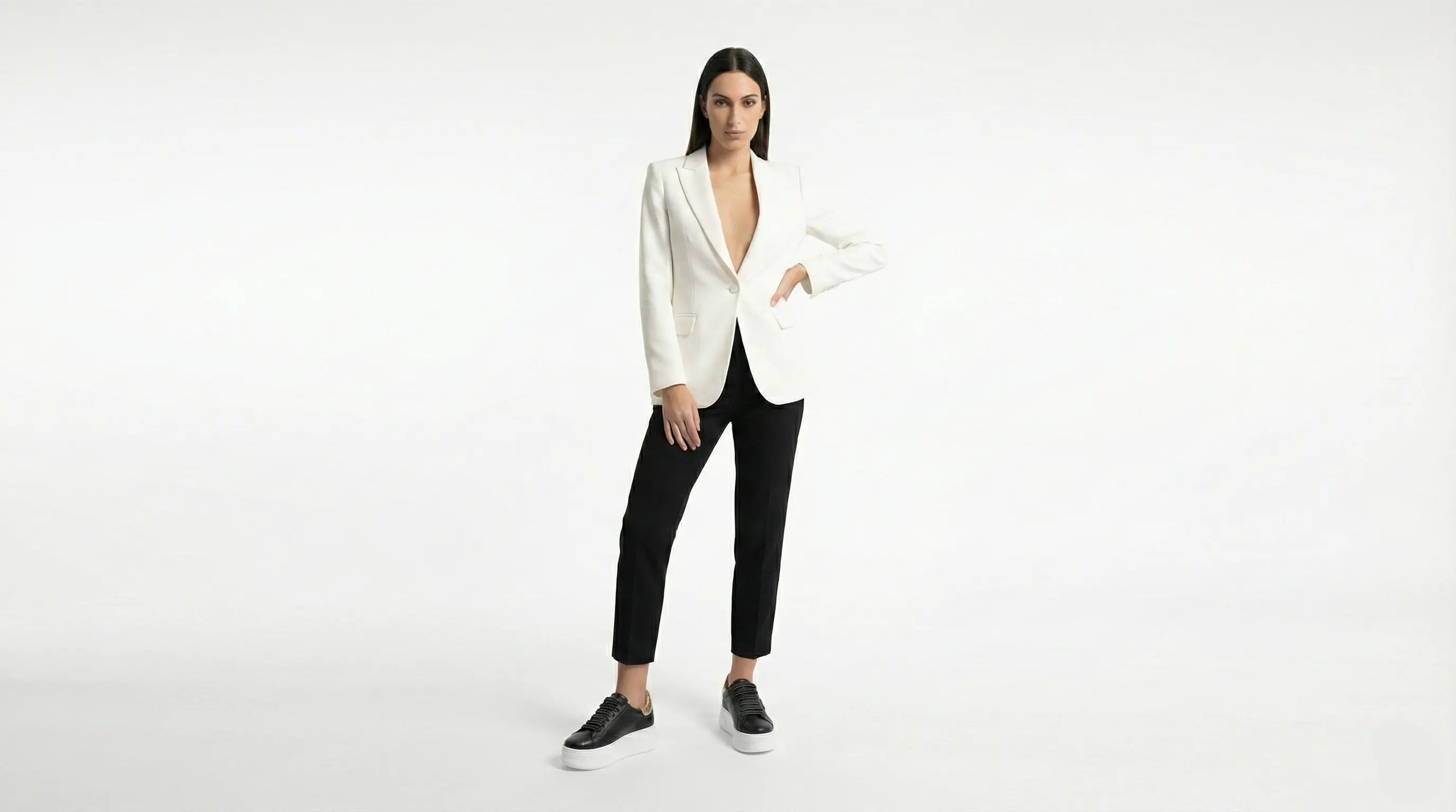 Person wearing a white blazer and black pants on a white background