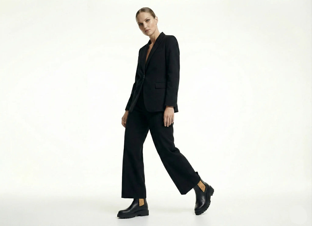 Person wearing a black suit on a white background