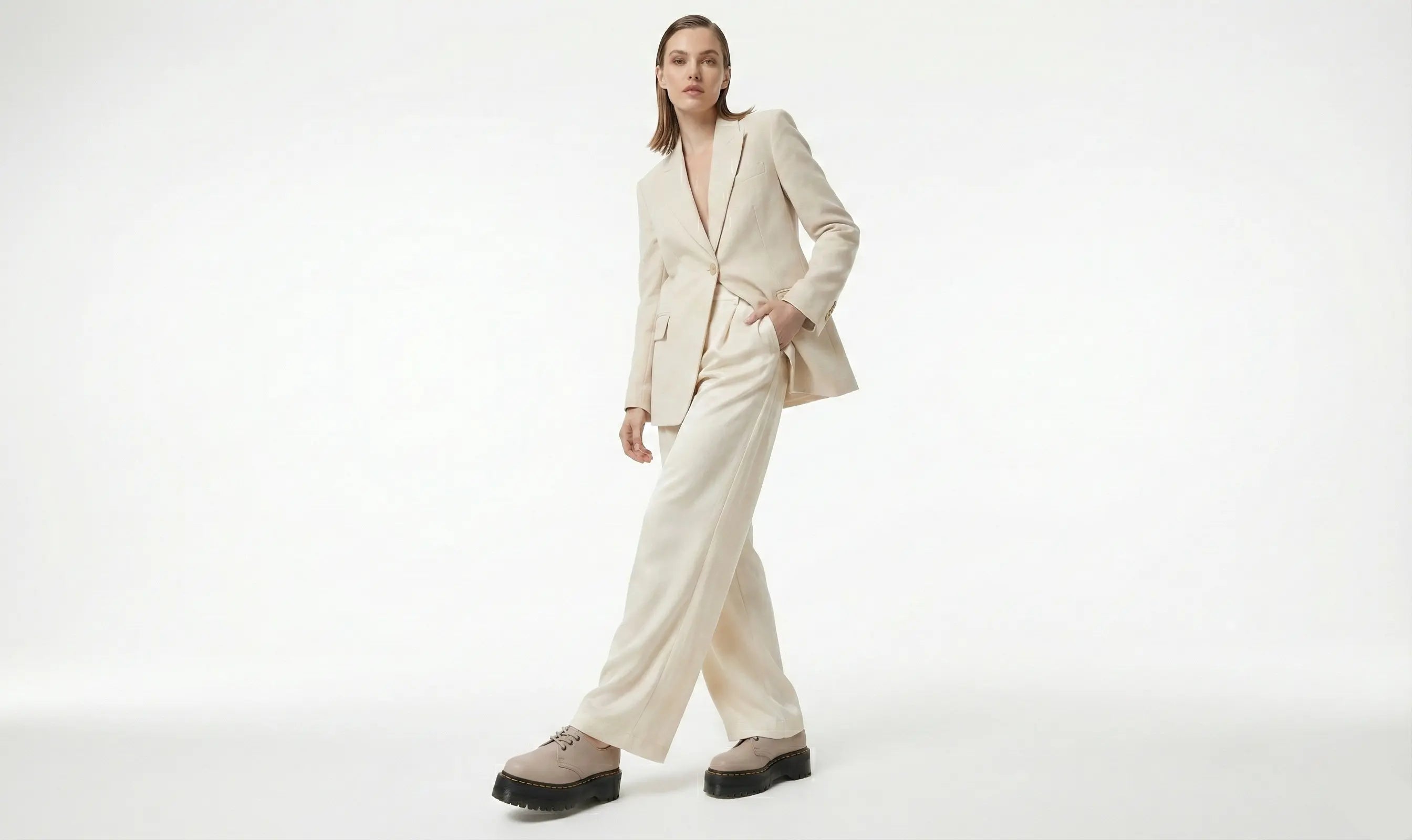 Woman wearing a beige suit on a white background