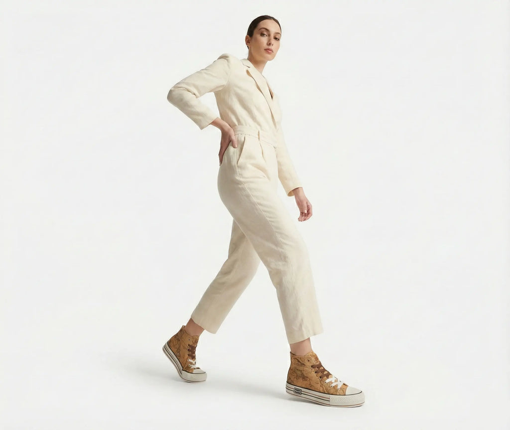 Person wearing a cream-colored outfit with high-top sneakers on a white background