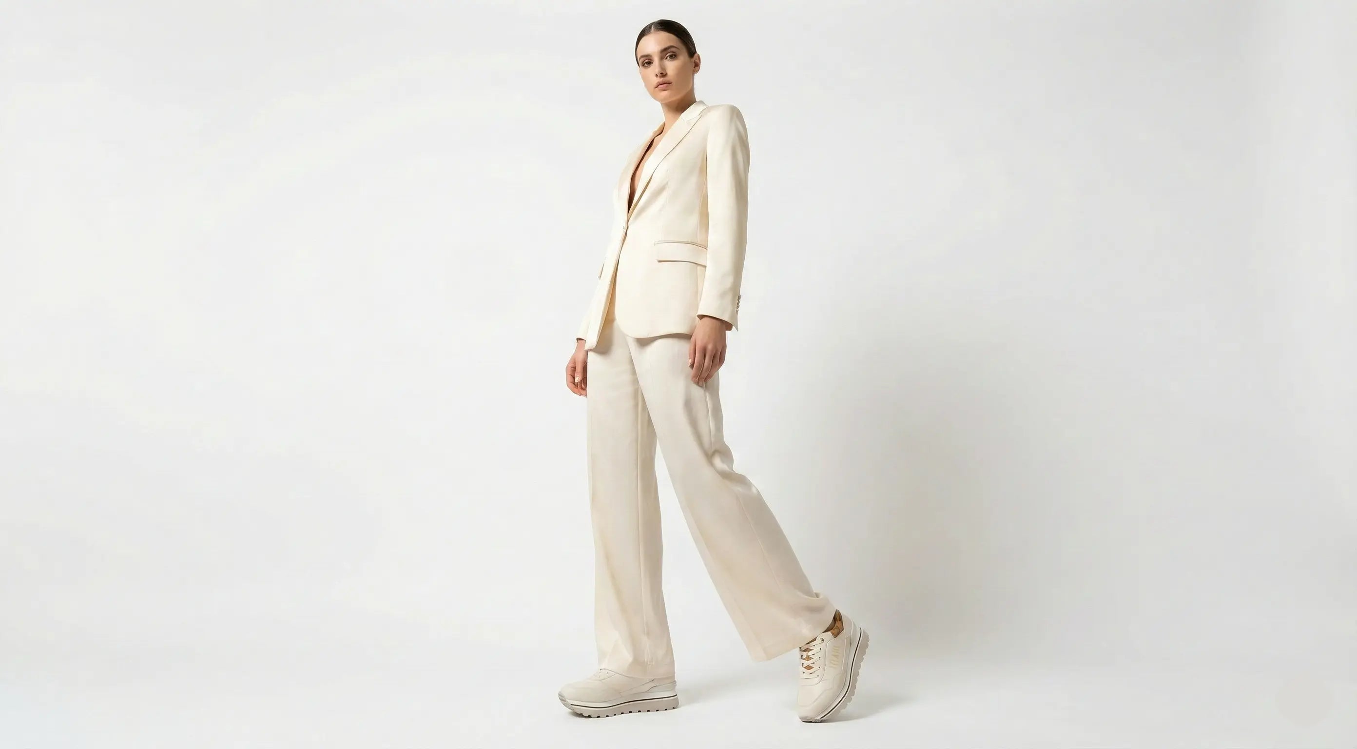 Person wearing a beige suit on a white background