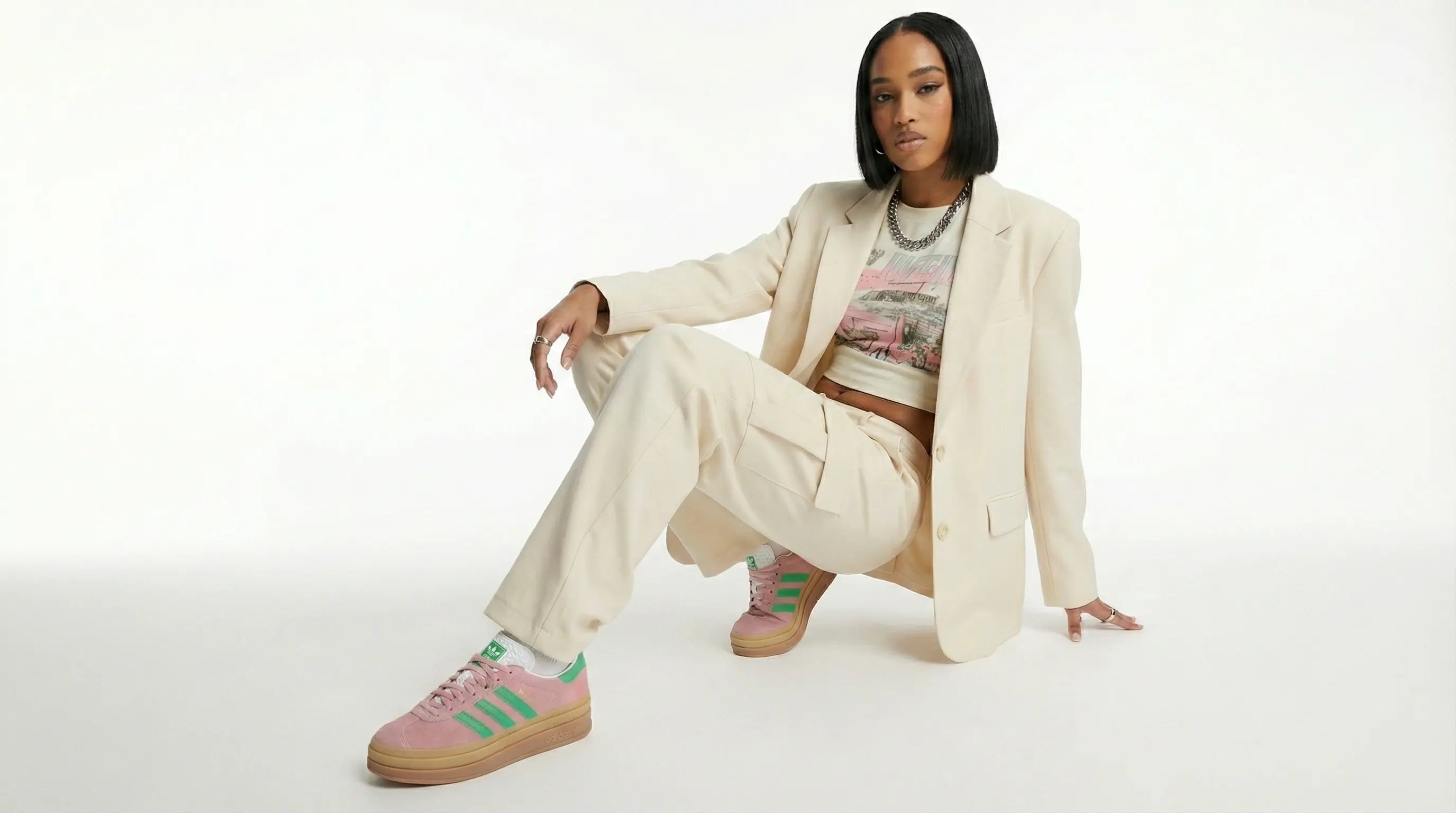 Person wearing a beige suit with colorful sneakers on a white background