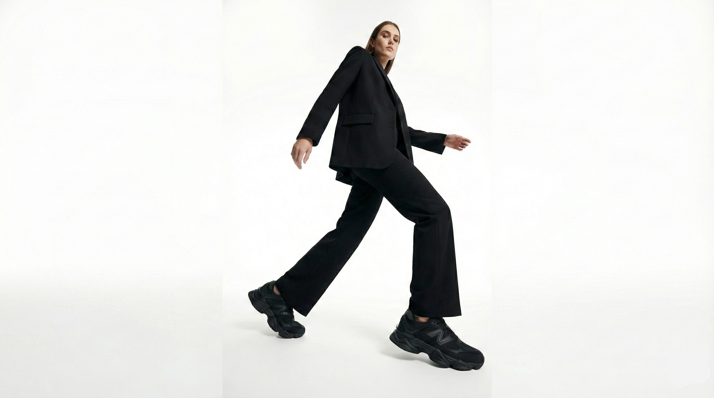 Person wearing a black suit and shoes on a white background